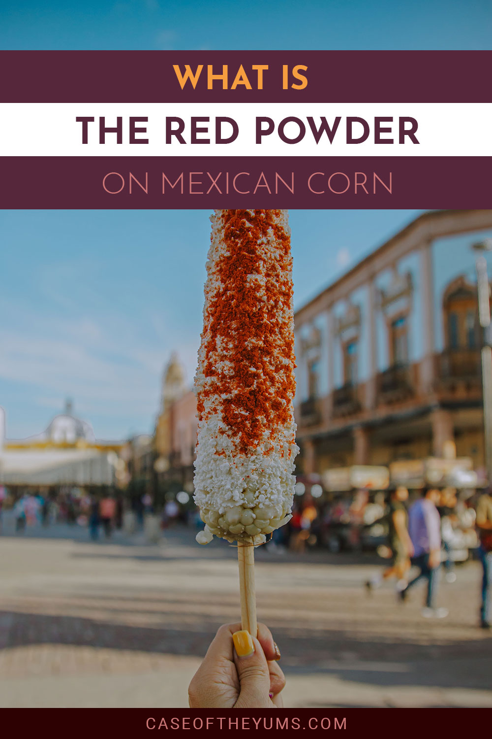 Woman holding a corn in hand outside - What is the Red Powder on Mexican Corn